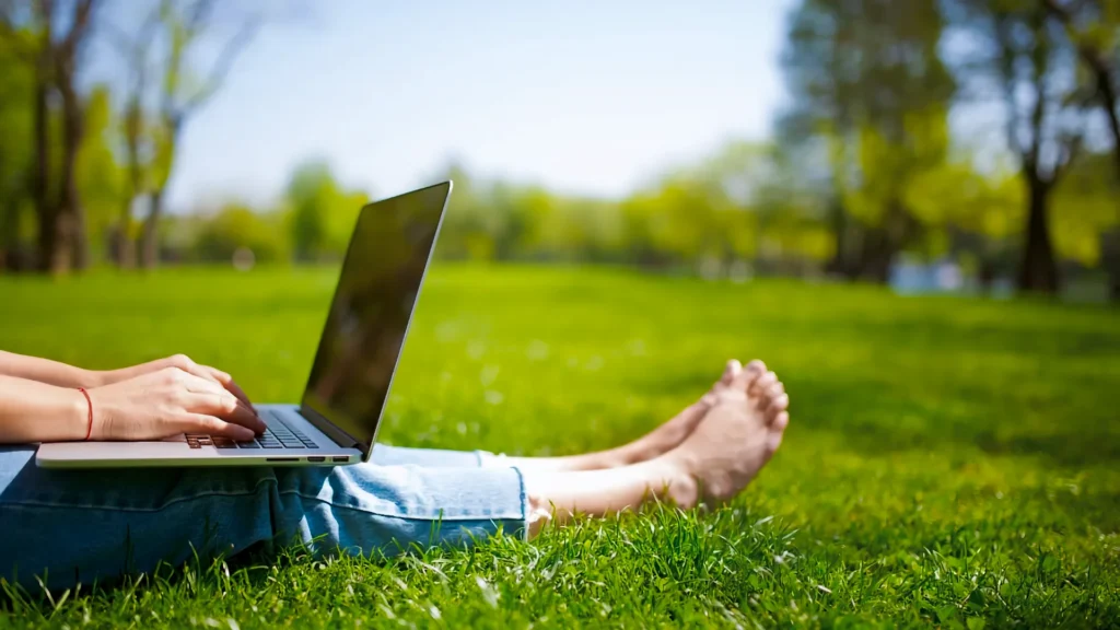 Met een refurbished laptop van TopLaptop kan je lekker buiten in het zonnetje en het gras werken